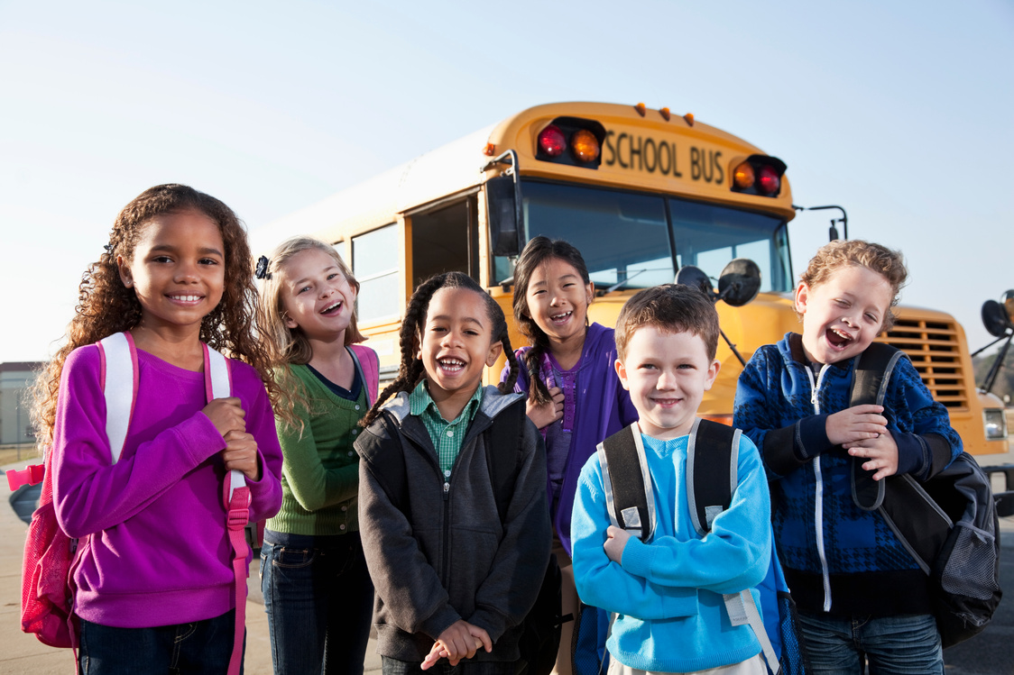 Children standing outside school bus